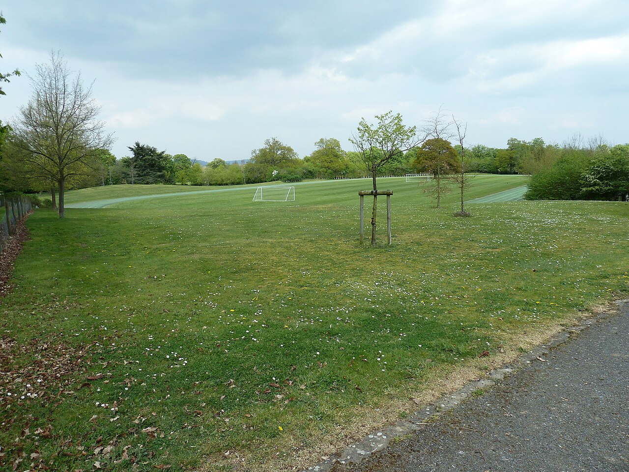 An athletics track surrounding shared grass playing fields